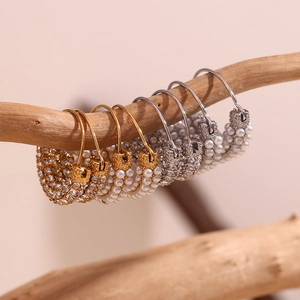 Detailed close-up of vintage hoop earrings with micro-inlaid pearls and diamonds on wood