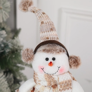 Cute Christmas snowman doll with striped knit hat and scarf for holiday table decoration