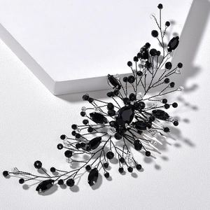 Detailed close-up of bridal hair comb with black wire, clear crystals and dark gemstones