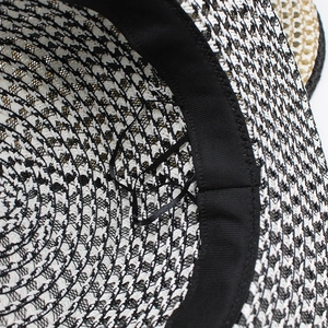 Detail of straw hat interior showing houndstooth weave, black sweatband and adjustable drawstrings