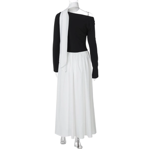 Detail view of a black long-sleeve dress with white pleated hem and matching scarf