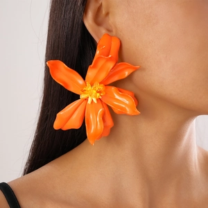 Side view of large orange resin flower earrings with yellow crystal beads on model