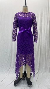 Detail of purple lace dress featuring intricate floral cutouts and a satin bow belt