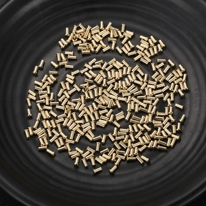 Precision turned gold stainless steel small hardware components on black textured tray