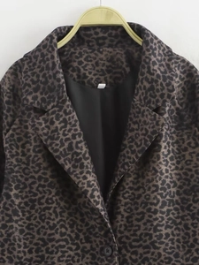 Close-up of animal print coat featuring notched lapel, buttons and sleek inner lining