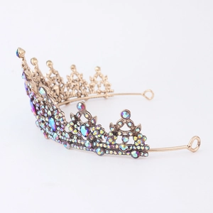 Close-up of vintage bronze alloy tiara with colorful rhinestones and hollow wave design