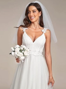 Detail of elegant white V-neck bridal gown featuring intricate lace embroidery and 3D floral accents