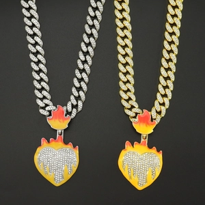 Detail view of hip-hop Cuban chains with iced-out melting heart flame pendants in gold and silver