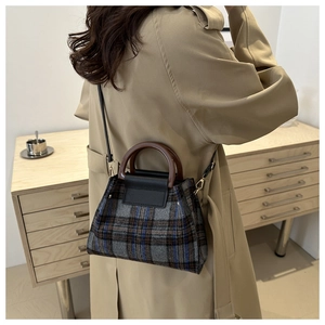 Mannequin portant un sac cabas en laine à carreaux avec poignée brune et trench beige