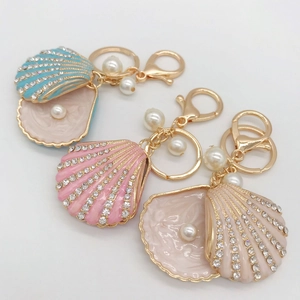 Detailed view of rhinestone shell keychains with pearls in blue, pink, and beige colors
