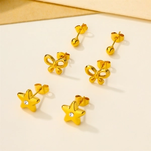 Detailed view of golden stud earrings set featuring ball, bow, and star designs