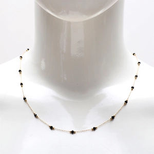 Detail view of 18K gold plated stainless steel necklace with black crystal beads on mannequin