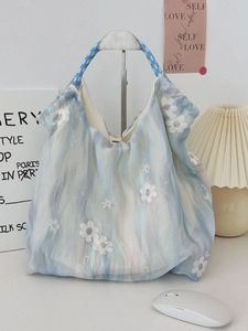Blue gradient embroidered tote bag with white floral details and braided handles