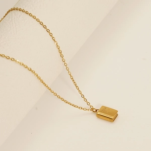 Detail of 18k gold Bible book pendant with cross engraving on a minimal chain