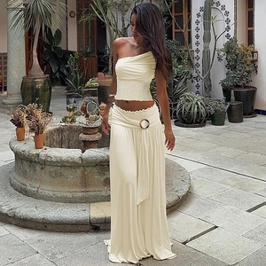 Detail of cream off-shoulder pleated top and high-waisted flowy maxi skirt set