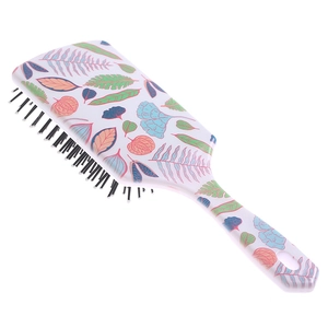 Detail view of large paddle hairbrush with colorful leaf patterns and soft massage bristles