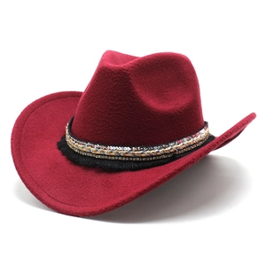 Detail of red wool felt western cowboy hat featuring ethnic braided band and black tassels