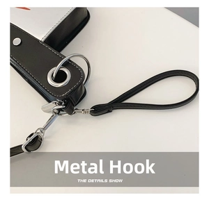Detail of silver metal hook and durable black faux leather strap on creative novelty bag