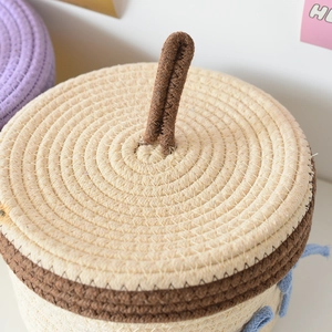 Detailed close-up of woven cotton rope basket lid with brown handle and beige texture