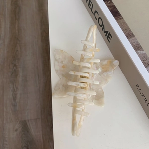 Detail view of large pearlescent acetate butterfly hair claw clip with elegant texture
