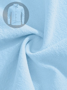 Detailed macro view of light blue linen fabric texture on men's long sleeve casual shirt