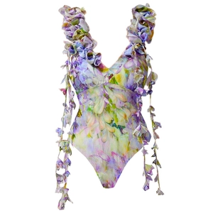Detail of 3D floral appliqués and purple wisteria print on the V-neck swimsuit