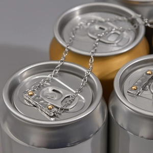 Macro view of two-tone soda can tab pendant necklace with hammered texture and gold rivets