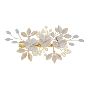 Handmade floral bridal hair clip with white petals, pearls and gold leaves on white background