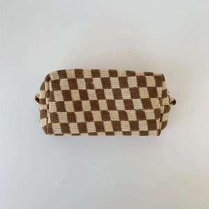 Detailed view of the checkered knit makeup bag with brown and beige woolen texture