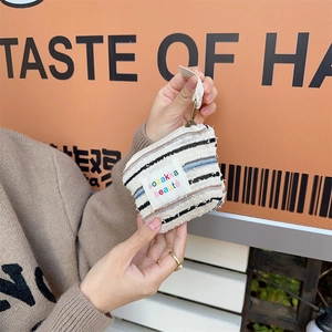 Detailed close-up of a striped canvas pouch with metal hook and woven brand label