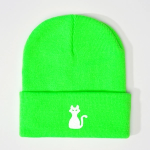 Gros plan du bonnet en maille vert fluo avec broderie de silhouette de chat blanc