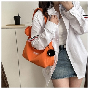 Détail du sac cabas en toile orange avec mini porte-monnaie assorti et breloque en peluche