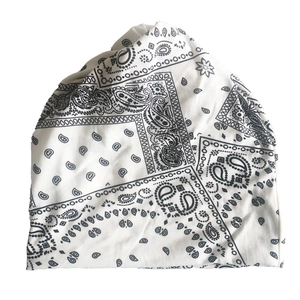 Close-up of black paisley pattern print on a white knit slouchy beanie hat