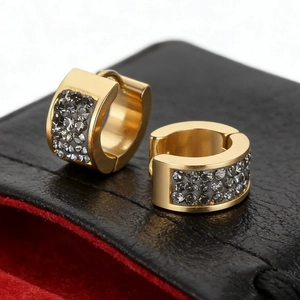 Macro shot of gold-plated hoop earrings with triple-row crystal pavé setting in a jewelry box