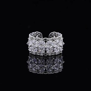 Sparkling silver flower open ring with clear zircon crystals on black background