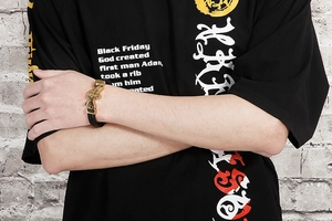 Detail showing high-polish gold cross charm and black woven leather on men's bracelet