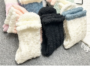 Detailed texture of thick coral fleece winter socks in multiple soft pastel colors