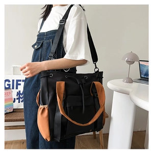 Large color-block tote bag in black and brown featuring drawstring closure and side pockets