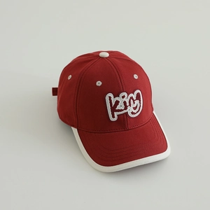 Detail of red baseball cap with white 3D King embroidery and reinforced brim stitching