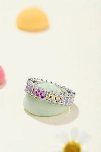 Macro shot of colorful baguette gemstones and zircon pavé on a silver band ring