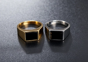 Detailed view of silver and gold signet rings with rectangular black stone inlays