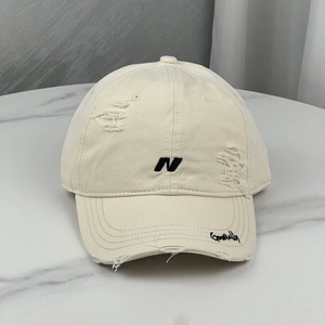 Detailed view of embroidery and distressed holes on this vintage baseball cap