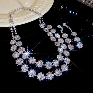 Detail of silver dual-layer floral necklace and earrings set with sparkling rhinestones