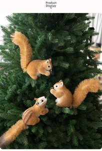 Three realistic squirrel ornaments with pinecones hanging on a green Christmas tree