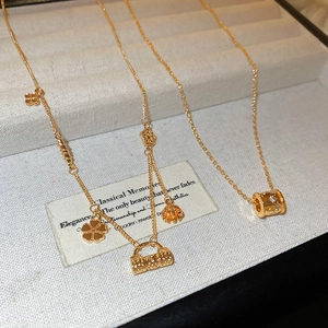 Close-up of 18k gold-plated flower lock and cylinder pendants on elegant necklaces