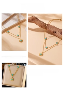 Detail of layered gold sun pendant necklace with turquoise stones in boho style