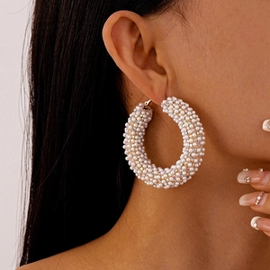 Macro view of French pearl and diamond hoop earrings on a female model with high detail