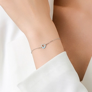 Elegant S925 sterling silver bracelet featuring blue heart charm on a model wrist