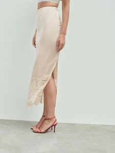 Detail of champagne satin midi skirt showing delicate lace trim and elegant side slit hem