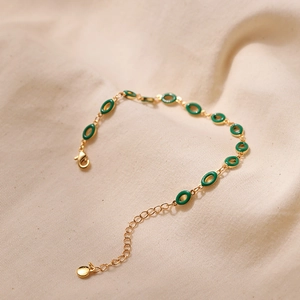 Vintage gold chain bracelet featuring green enamel oval charms and lobster clasp closure